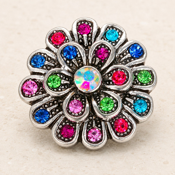 multi-color rhinestone flower snap jewelry charm with a central iridescent stone and petals adorned with blue, pink, green, and red rhinestones in a silver-tone setting
