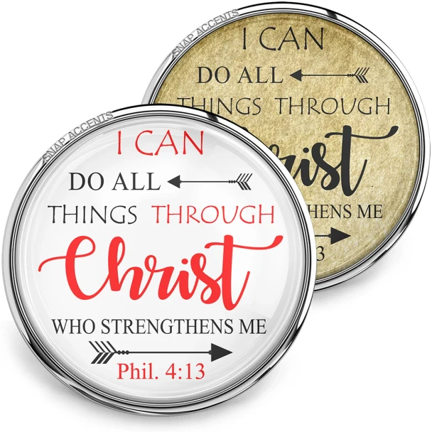 SnapAccents snap jewelry featuring inspirational Bible verse "I can do all things through Christ who strengthens me" Phil. 4:13, two interchangeable snap charms with white and gold backgrounds, displayed with a silver cross necklace on a tan surface.