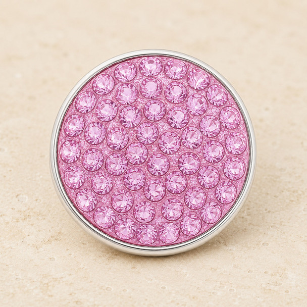 round snap jewelry charm covered with multiple light pink rhinestones set in a silver-tone metal base
