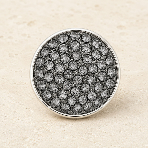 round snap jewelry charm covered with multiple small gray rhinestones set in a silver-tone metal base