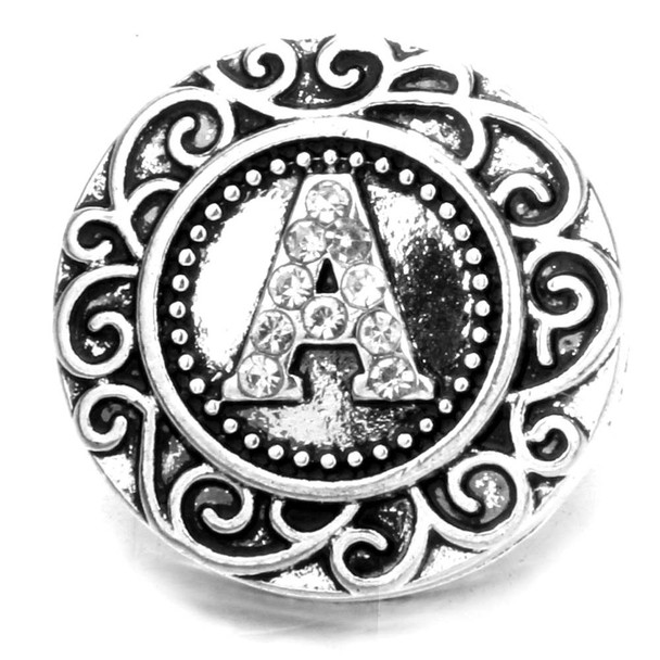 Silver SnapAccents snap jewelry charm with ornate scrollwork border and rhinestone-studded letter "A" centerpiece, decorative round design, interchangeable accessory for bracelets, necklaces, and fashion jewelry, vintage-inspired style, elegant and customizable snap button charm.