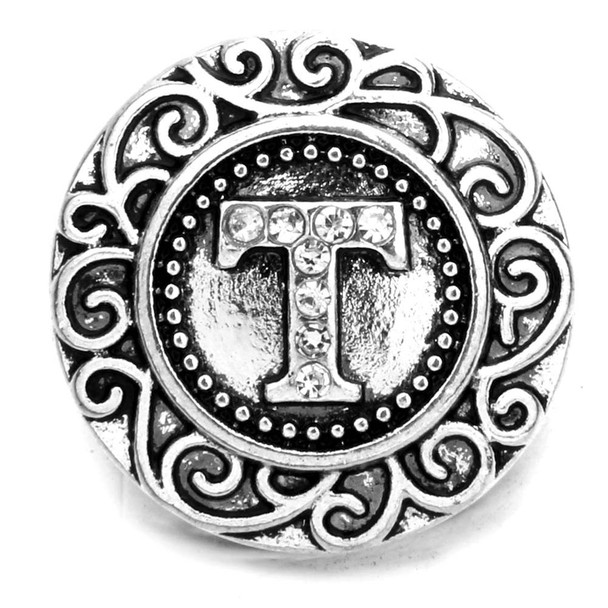 Silver SnapAccents snap jewelry charm with ornate scrollwork border and rhinestone-studded letter "T" centerpiece, decorative round interchangeable button accessory for bracelets and necklaces.