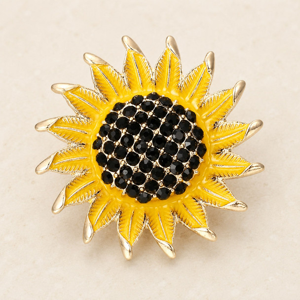 snap jewelry charm shaped like a sunflower with bright yellow enamel petals tipped in gold and a center filled with clustered black rhinestones