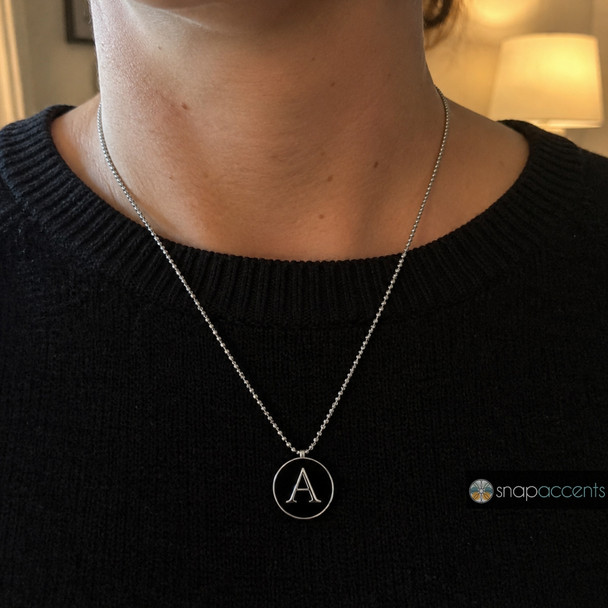 silver necklace with a round black snap jewelry charm featuring a polished silver letter A on a ball chain