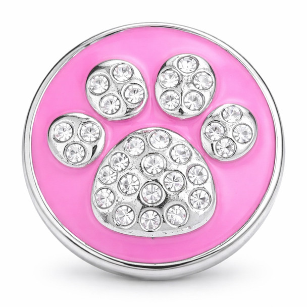 round pink enamel snap jewelry charm featuring a silver dog paw design studded with clear rhinestones