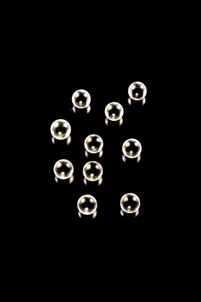 Ten clear 4 mm quartz banger beads arranged on black; terp pearl set for head-shop wholesale catalogs, overhead studio view.