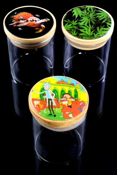 Wholesale clear 3.5-inch glass stash jars with bamboo pop-top lids and assorted decal artwork, tri-jar angled display