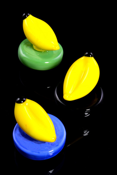 Trio of glass banana carb caps with green, black, and blue bases on black background; wholesale head-shop carb cap set.