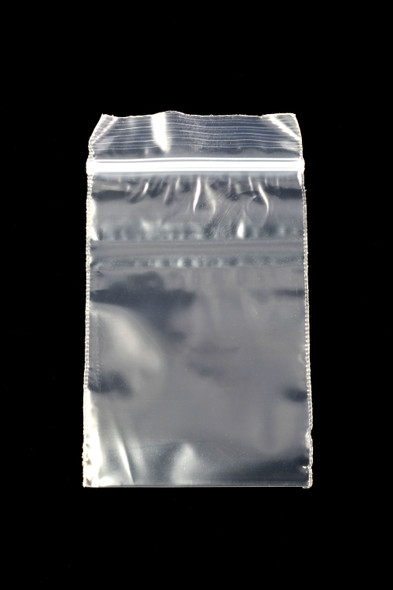 Wholesale 2 × 3 inch clear apple-print zip-top baggie, red apple icon centered, empty pouch on black background, overhead studio view