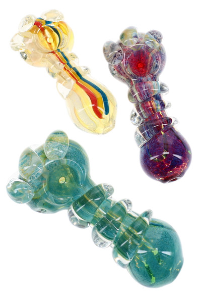 Three thick glass spoon pipes in yellow, teal, and purple with colorful stripes, frit patterns, and raised marbles