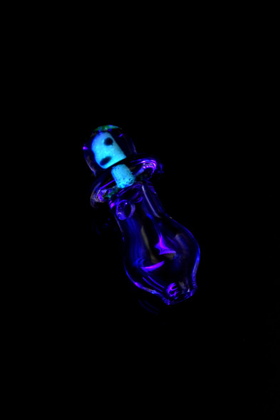 UV-reactive Martian Peak Pro glass ball cap glowing blue-purple on black; 1" borosilicate accessory for wholesale head-shop displays.
