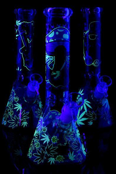 UV-lit 10" glass beaker water pipes with glow-in-the-dark alien and leaf decals, 18.8 mm setup, front trio angle for wholesale buyers.