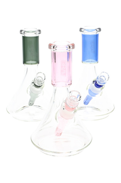 GRAV small deco beaker water pipes with pink, smoke grey, and light cobalt accents; clear borosilicate bodies, studio group angle for wholesale catalogs.