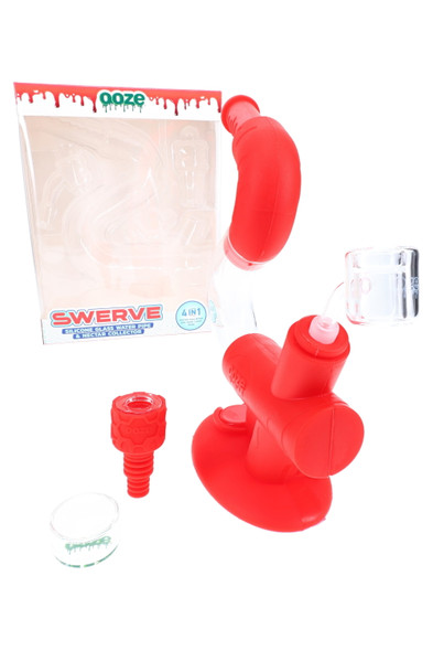 Scarlet Ooze Swerve silicone/glass 4-in-1 water pipe kit with bowl, banger, nail, and dish, unboxed next to retail packaging, angled view for wholesale. Scarlet Ooze Swerve silicone/glass 4-in-1 water pipe kit with bowl, banger, nail, and dish, unboxed next to retail packaging, angled view for wholesale.