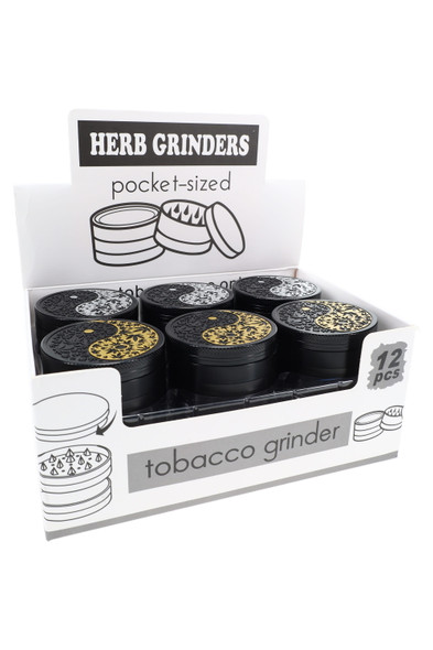 Twelve black Yin Yang leaf metal grinders in a white counter display box labeled herb grinder, ideal head shop fixture.