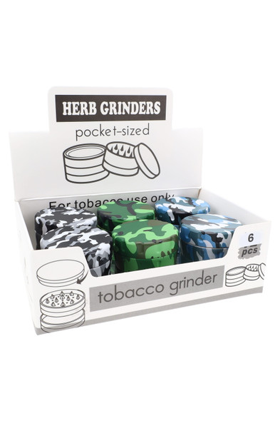Counter display with six assorted camo plastic and metal herb grinders, pocket-sized and shelf-ready for smoke shop sales.