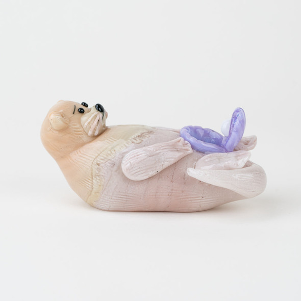 Handcrafted borosilicate glass sea otter pipe featuring purple shell accent and detailed lampwork