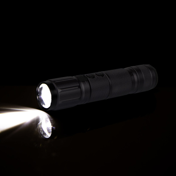 Cartisan High-Beam flashlight illuminated in a dark setting with bright beam reflecting from a surface