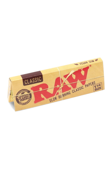 Bulk RAW Classic 1¼ rolling papers single booklet, natural unrefined paper with natural gum, kraft design, studio angled close-up on white.