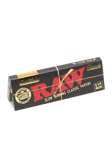 Retail 1¼ RAW Black rolling papers single pack, 50 leaves, black booklet with red RAW logo and gold accents, close-up angled studio shot.