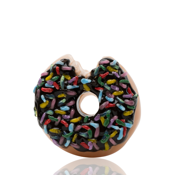 Front angle of donut-shaped glass dry pipe showing bite detail and center hole, glossy glaze and sprinkles; B2B retail smoke gear product shot. Front angle of donut-shaped glass dry pipe showing bite detail and center hole, glossy glaze and sprinkles; B2B retail smoke gear product shot.