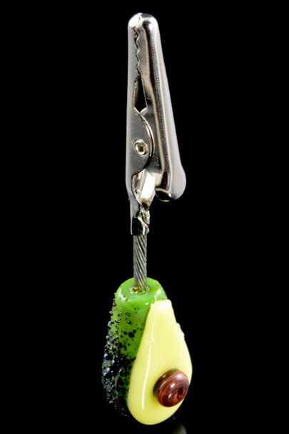 Wholesale avocado alligator clip, 3.6" borosilicate glass with brown seed and metal clamp, front angle on black background.