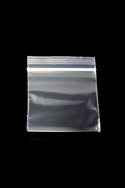 Wholesale 1.75-inch clear zip-top baggie, 1.75 × 1.75 sample size, single empty pouch on black background for head-shop packaging display