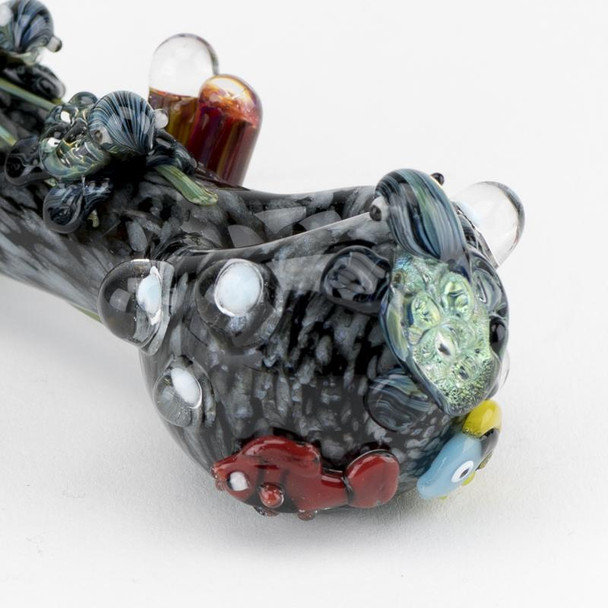 Macro close-up for B2B catalogs showing bowl end of 4.5" ocean-current spoon with textured dots, sea creature detail, and colorful reef marbles.