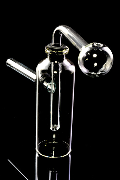 4" clear glass bottle bubbler with globe burner head, side mouthpiece and rubber grommet, studio close-up for head-shop wholesale listings.