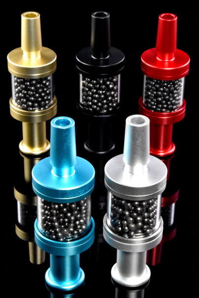 Assorted Pike tar filters in gold, black, red, silver, and blue with carbon beads, retail smoke-shop gear, reflective black studio setup.