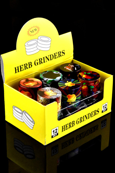 Second angle, yellow 12-piece display of assorted zinc-alloy 4-part grinders; head-shop counter merchandising view.