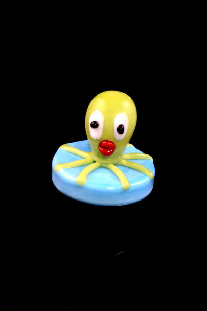 Green octopus carb cap on light blue base; glass material, wholesale dab accessory, straight-on view.