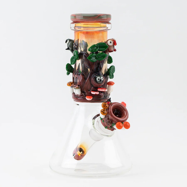 Front angle of 8.5" US-made baby beaker with fumed neck, tree wrap, critters and mushroom bowl; wholesale head-shop water pipe on white background.