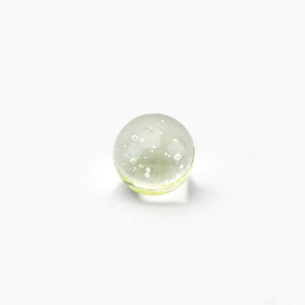 Clear UV-reactive banger bead with tiny air bubbles, small round terp pearl for spinner caps; macro product detail for B2B concentrate accessory listings.