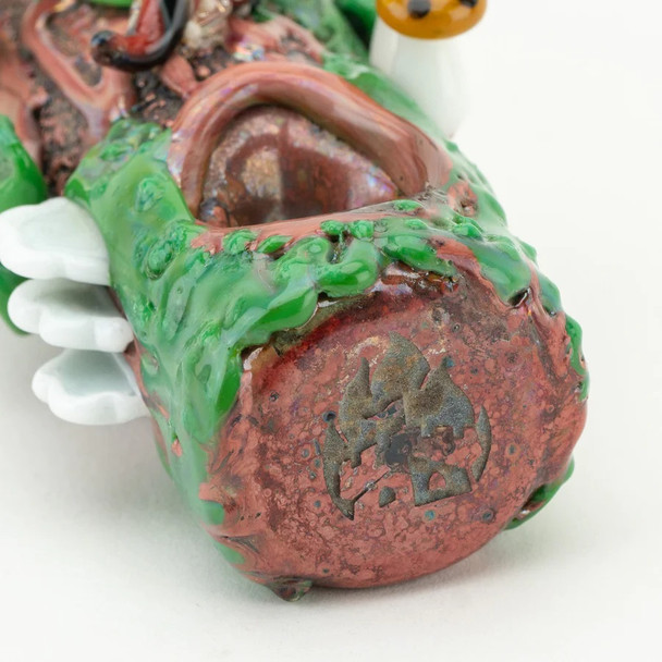 Close macro of mushroom appliqués and moss detail on log pipe; novelty head-shop accessory image for B2B product pages.