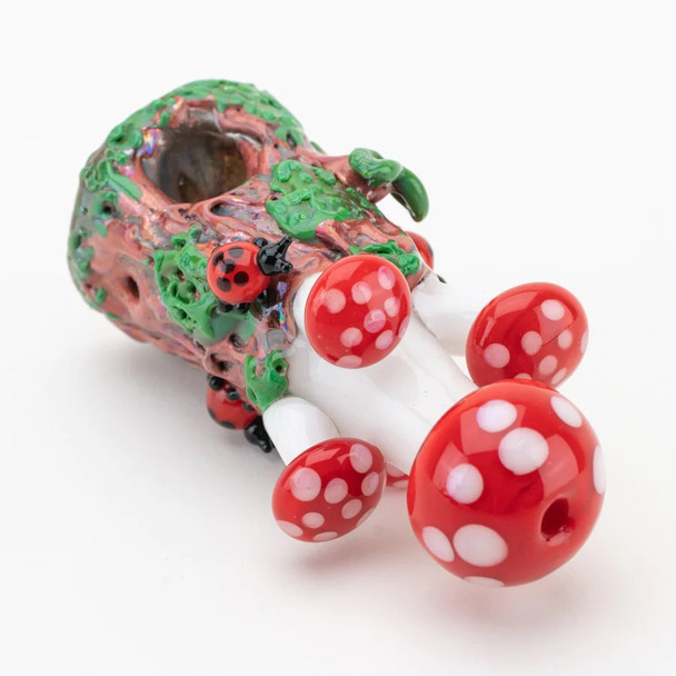 Mushrooms dry pipe laid on side showing five red caps and bowl opening; novelty glass hand pipe for wholesale catalogs, detailed underside view.