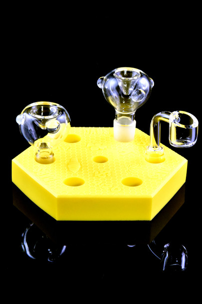 Head-shop supplies yellow silicone bowl display loaded with clear glass bowls and quartz banger, 5-inch hex stand on glossy black background