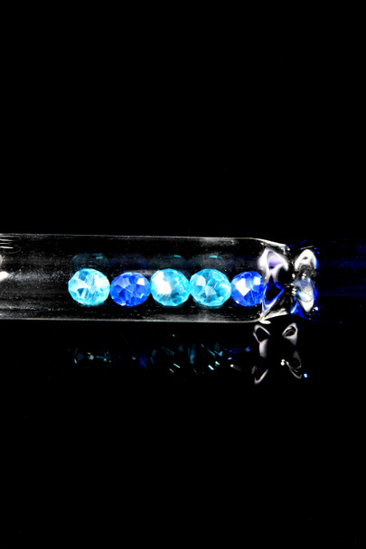 Close-up of 8" clear glass oil burner tube with blue crystal filter beads, black background—wholesale smoke shop detail view.