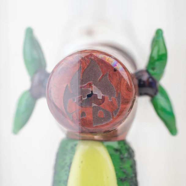 Macro close-up of marbled red logo marble with leaf accents above avocado sculpt; product detail for wholesale listing.