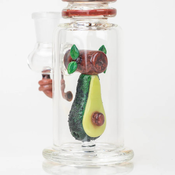 Close angle on halved avocado sculpt with pit and textured rind inside chamber; head-shop inventory detail, clear base on white.