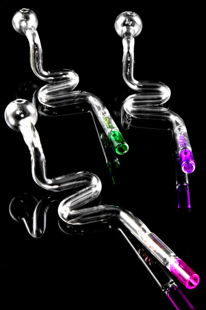 8.5" clear glass snake oil burner pipes with green and purple crystal filter tips on black, angled top view—wholesale head-shop photo.