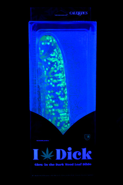 8" clear weed-leaf glow dildo in UV-lit retail window box, suction-cup base visible; wholesale adult novelty, front view with hang tab.