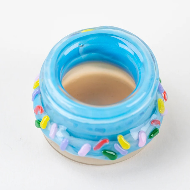 Retail smoke gear mini donut terp jar, top view of open 1.5-inch blue glass container encircled by raised candy sprinkles for airtight concentrate storage. Retail smoke gear mini donut terp jar, top view of open 1.5-inch blue glass container encircled by raised candy sprinkles for airtight concentrate storage.