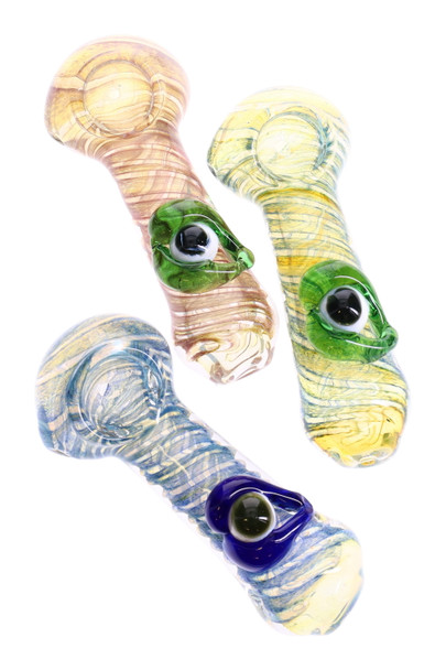 Three 4.5" color-changing glass spoon pipes with spiral frit and raised eyeball marbles, assorted hues; wholesale head-shop photo, top-down angle. Three 4.5" color-changing glass spoon pipes with spiral frit and raised eyeball marbles, assorted hues; wholesale head-shop photo, top-down angle.