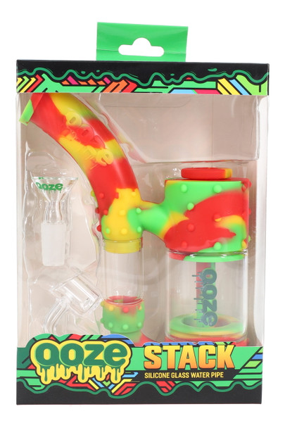 Rasta Ooze Stack silicone/glass water pipe kit in branded window box, bowl and banger visible, straight-on retail packaging shot for smoke-shop wholesale. Rasta Ooze Stack silicone/glass water pipe kit in branded window box, bowl and banger visible, straight-on retail packaging shot for smoke-shop wholesale.