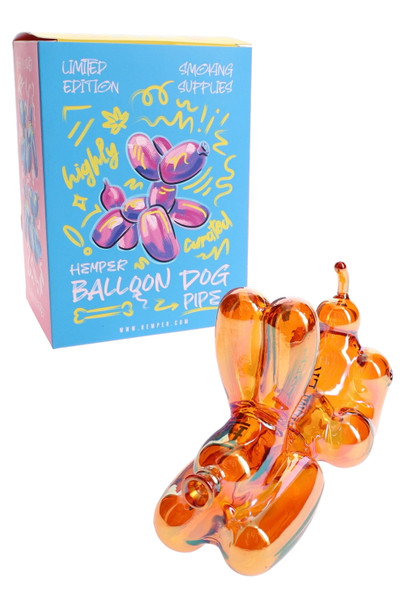 Hemper Balloon Dog amber glass hand pipe posed before bright blue limited-edition retail box, shelf-ready presentation for head-shop glass displays.