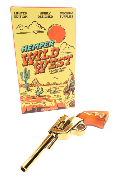 Hemper Wild West Peacemaker gold revolver hand pipe displayed in front of tall yellow Wild West box, limited edition packaging for head-shop buyers.