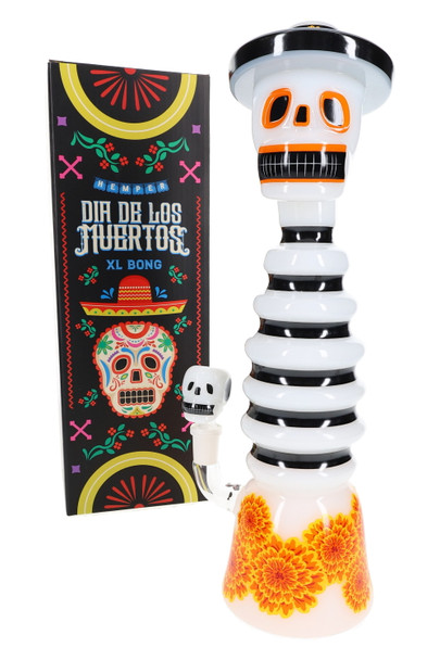 13" Hemper Dia De Los Muertos XL skull bong beside black sugar-skull box, angled on white for smoke shop wholesale buyers.