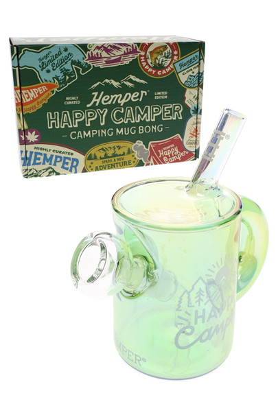 Hemper Happy Camper iridescent green mug bong posed before sticker-covered camping retail box, shelf-ready setup shot for head-shop water pipe buyers.