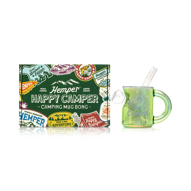 Green Happy Camper camping mug bong displayed beside matching Hemper adventure box, wide hero image aimed at retail smoke gear and gift buyers.